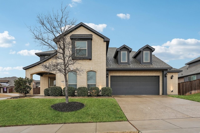 view of front of home with driveway, a front yard, a shingled roof, a garage, and brick siding