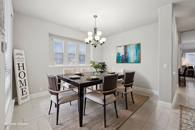 dining area featuring a notable chandelier and baseboards