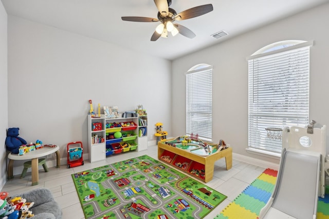 rec room with tile patterned floors, visible vents, baseboards, and a ceiling fan