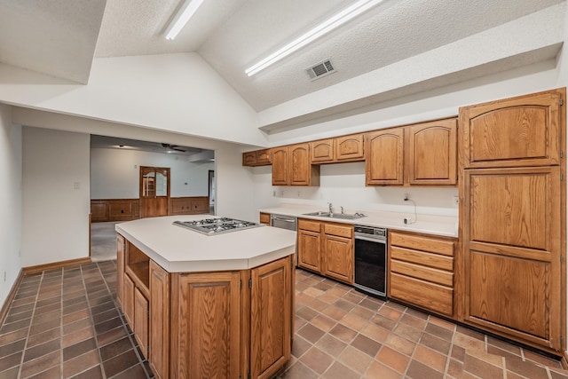 kitchen featuring visible vents, a sink, stainless steel gas stovetop, light countertops, and lofted ceiling