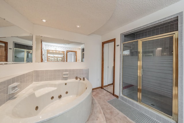 bathroom with tile patterned floors, a shower stall, a jetted tub, and a textured ceiling