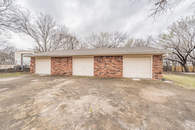 detached garage featuring fence