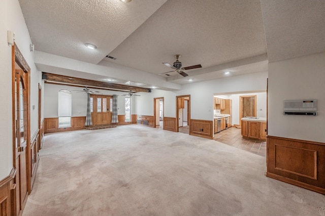 interior space featuring a ceiling fan, a wainscoted wall, recessed lighting, a textured ceiling, and light carpet