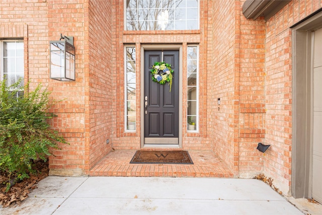 view of exterior entry with brick siding