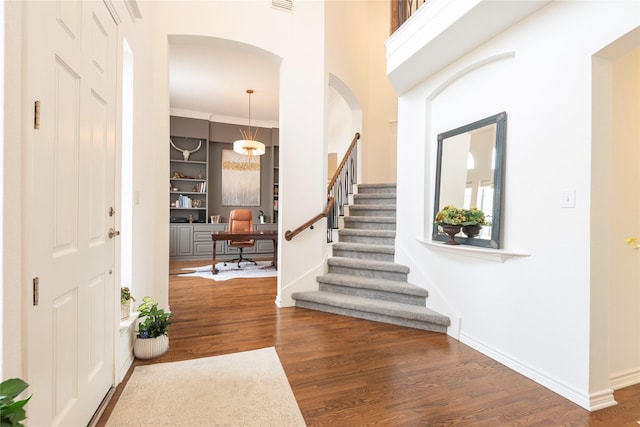 entryway with stairway, wood finished floors, visible vents, baseboards, and arched walkways