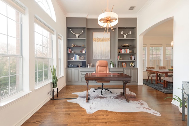 office featuring visible vents, arched walkways, wood finished floors, and ornamental molding