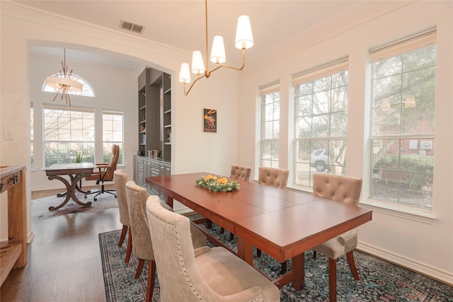 dining area with dark wood finished floors, crown molding, baseboards, and visible vents