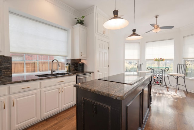 kitchen with crown molding, black electric cooktop, dark wood-style floors, and a sink