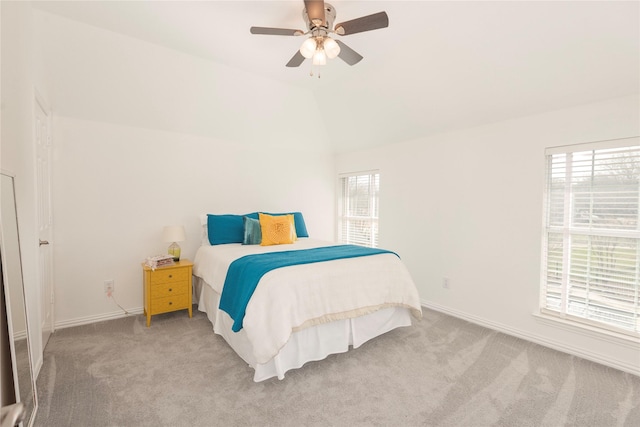 carpeted bedroom featuring baseboards, lofted ceiling, and a ceiling fan