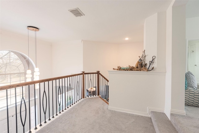 hall with ornamental molding, carpet, visible vents, and baseboards