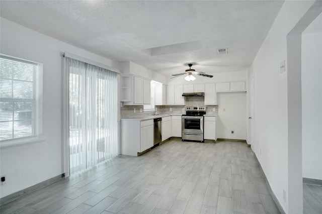 kitchen featuring open shelves, stainless steel appliances, under cabinet range hood, white cabinetry, and backsplash