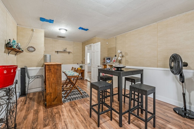 dining area with visible vents, a textured ceiling, and wood finished floors