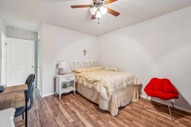 bedroom featuring wood finished floors, baseboards, a closet, and ceiling fan