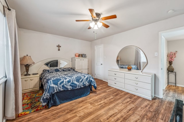 bedroom featuring a ceiling fan, wood finished floors, and baseboards