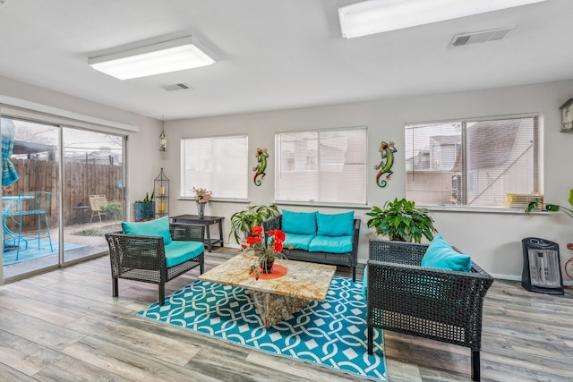 living area with visible vents, baseboards, and wood finished floors