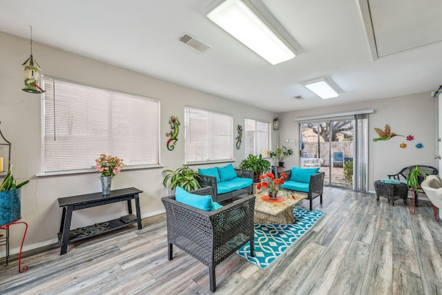 interior space with visible vents, baseboards, attic access, and wood finished floors