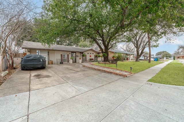 ranch-style home with driveway, a front lawn, and fence