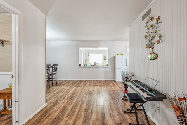 interior space with visible vents, baseboards, and wood finished floors