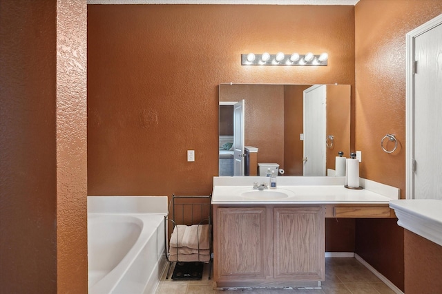 full bathroom featuring tile patterned floors, vanity, a garden tub, and a textured wall