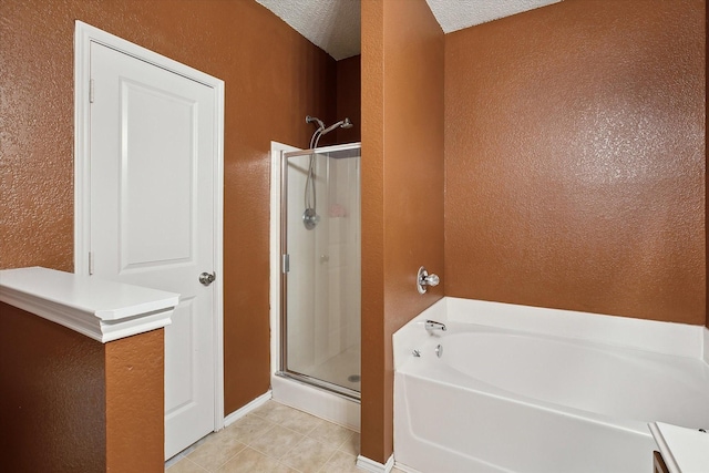 full bath featuring a shower stall, a garden tub, a textured wall, tile patterned floors, and a textured ceiling