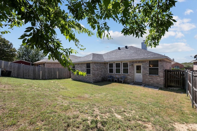 back of property featuring a fenced backyard, a shingled roof, a chimney, a lawn, and brick siding