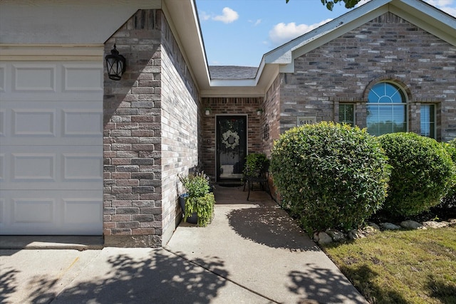 doorway to property with brick siding and an attached garage