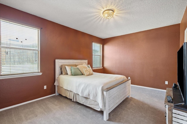 bedroom featuring a textured ceiling, carpet, and a textured wall