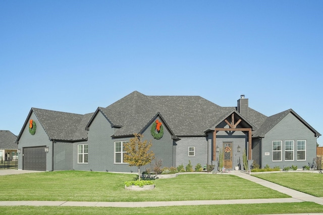 view of front of home with a front yard, concrete driveway, brick siding, and a chimney