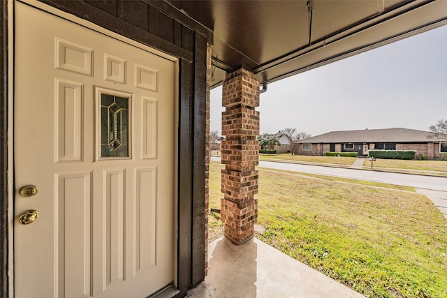 view of exterior entry with a lawn