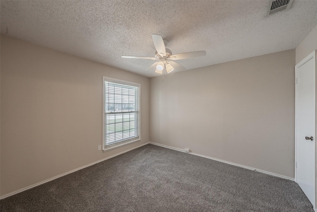 spare room with visible vents, a ceiling fan, a textured ceiling, dark colored carpet, and baseboards