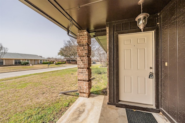 view of exterior entry featuring a yard