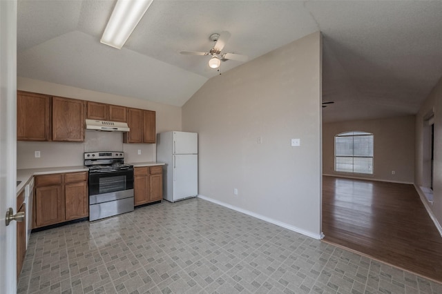 kitchen featuring electric stove, under cabinet range hood, open floor plan, freestanding refrigerator, and brown cabinetry