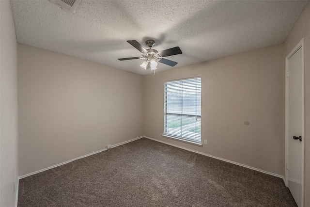 spare room featuring visible vents, a ceiling fan, a textured ceiling, dark colored carpet, and baseboards