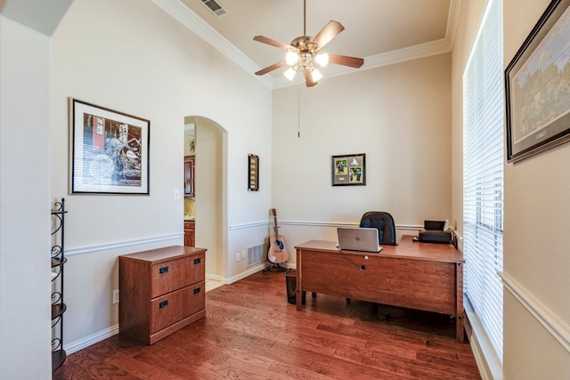 office area with arched walkways, wood finished floors, a ceiling fan, and ornamental molding