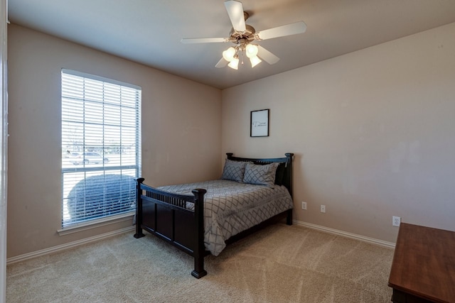 bedroom with ceiling fan, baseboards, and carpet