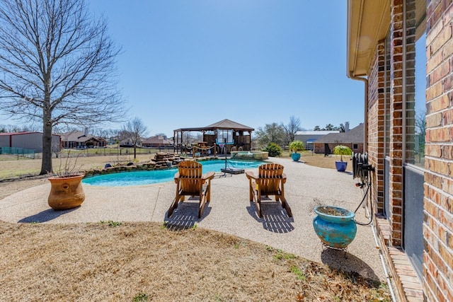 view of pool with a patio area, a pool with connected hot tub, and a gazebo