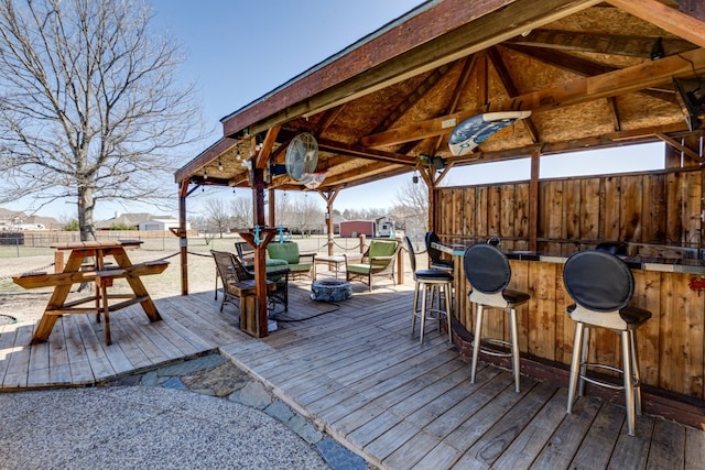 wooden deck featuring outdoor dry bar, a gazebo, and fence