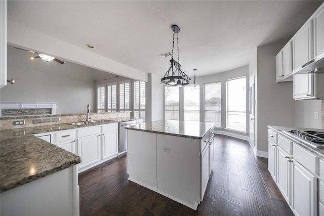 kitchen featuring visible vents, dark wood-style flooring, a sink, appliances with stainless steel finishes, and white cabinetry