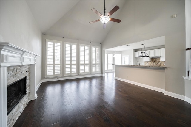 unfurnished living room with plenty of natural light, dark wood finished floors, and a fireplace