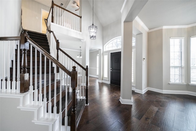 entryway with a wealth of natural light, baseboards, a notable chandelier, and hardwood / wood-style floors