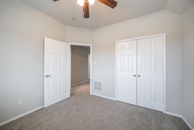 unfurnished bedroom featuring visible vents, baseboards, vaulted ceiling, carpet floors, and a closet