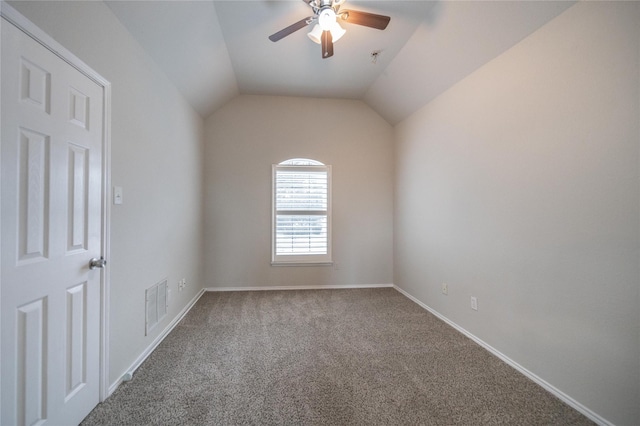 empty room with visible vents, baseboards, ceiling fan, vaulted ceiling, and carpet flooring