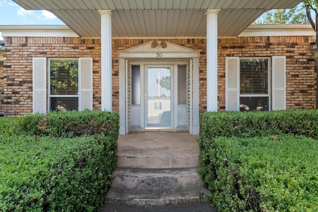 view of exterior entry with brick siding