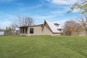 rear view of property with fence and a lawn