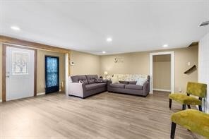 living area with recessed lighting, visible vents, and wood finished floors