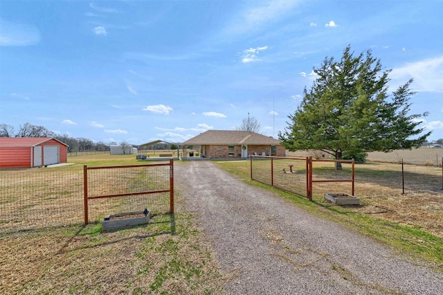 view of street featuring a rural view, driveway, and a gated entry