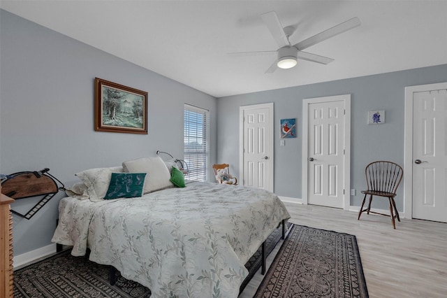 bedroom with a ceiling fan, light wood-style floors, and baseboards