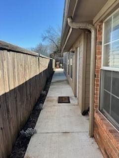 view of home's exterior featuring brick siding and fence