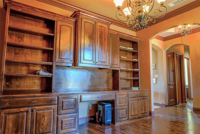 unfurnished office featuring visible vents, a chandelier, dark wood finished floors, ornamental molding, and arched walkways