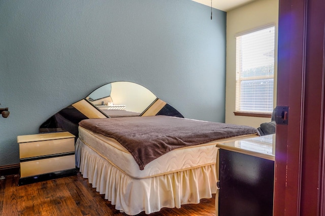 bedroom with dark wood-style flooring